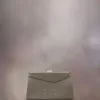 Kleine clutch met gesmokte schouder